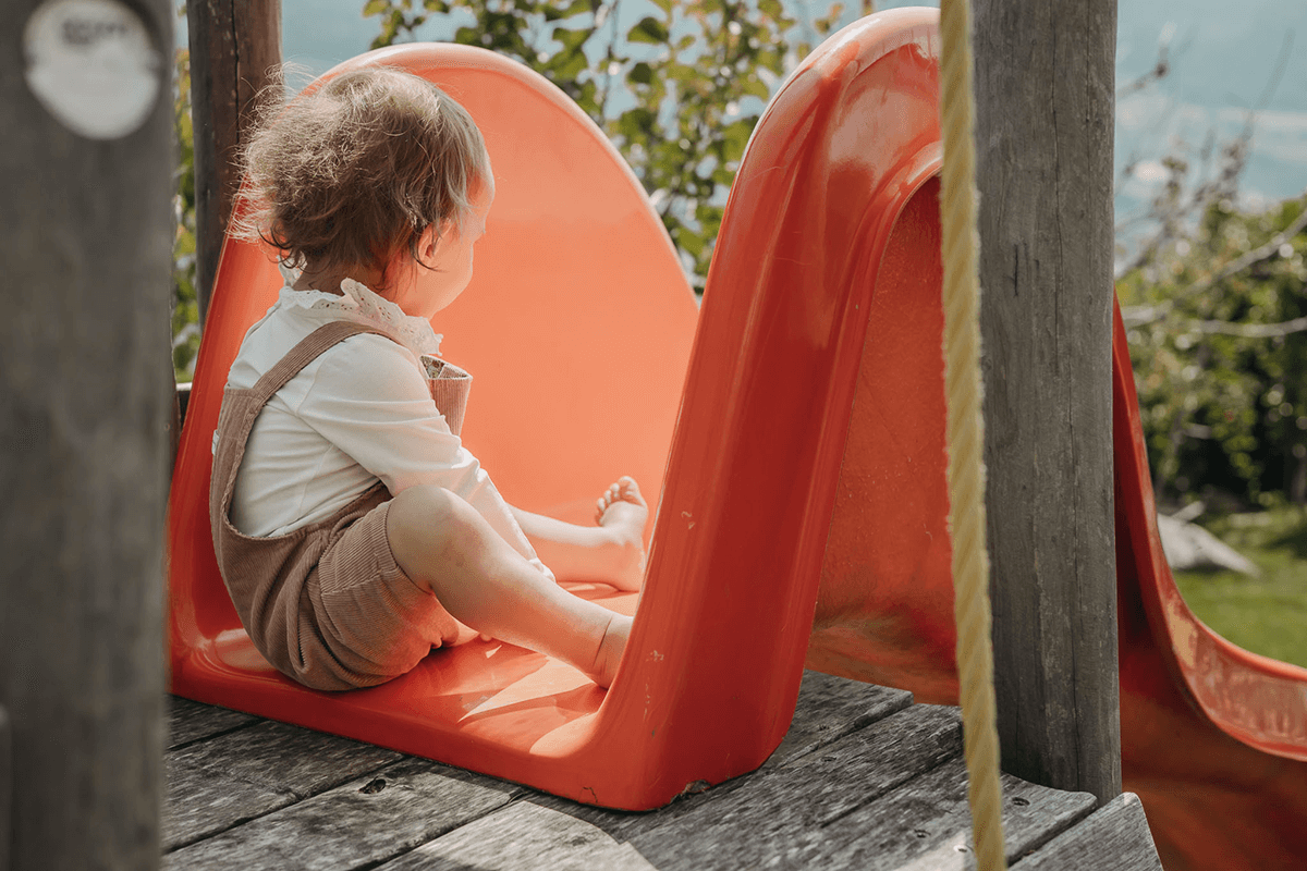 Kind sitzt auf einer Rutsche